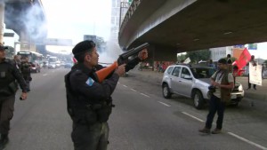 Rio de Janeiro Rio de Janeiro, 7h37 PM saca arma não letal próximo a manifestantes em local onde foi jogada bomba de efeito moral - Foto Reprodução TV Globo